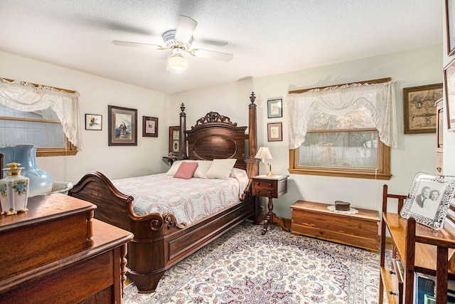 bedroom with ceiling fan and a textured ceiling