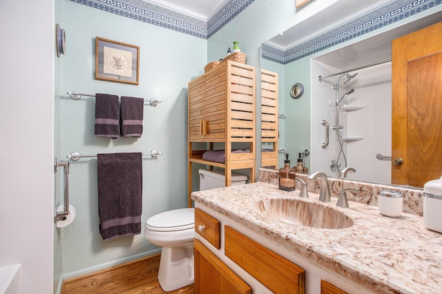 bathroom with ornamental molding, vanity, a shower, wood-type flooring, and toilet