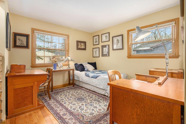 bedroom with light wood-type flooring and multiple windows