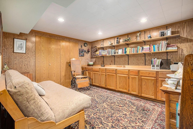 living area with built in features and wood walls