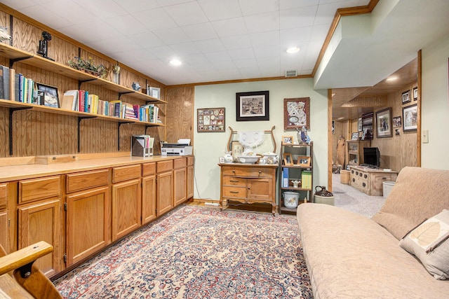 office featuring crown molding, light carpet, and wood walls