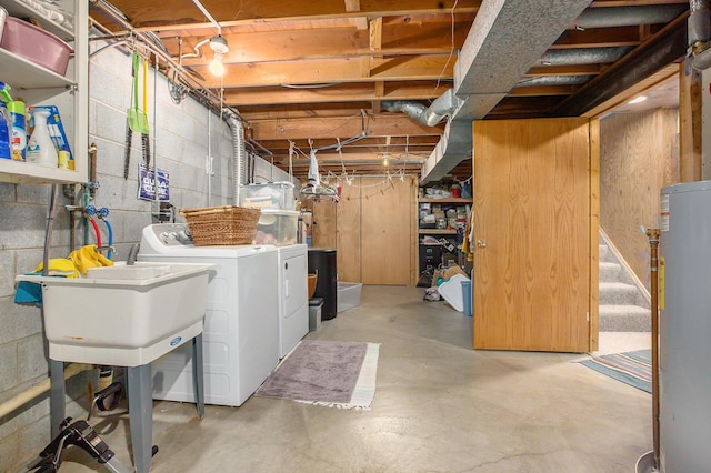 basement with washing machine and dryer, water heater, and sink