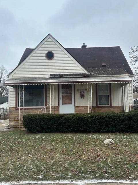 view of front of property with covered porch and a front lawn