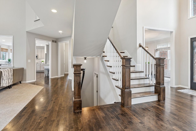 stairs with a high ceiling and hardwood / wood-style flooring