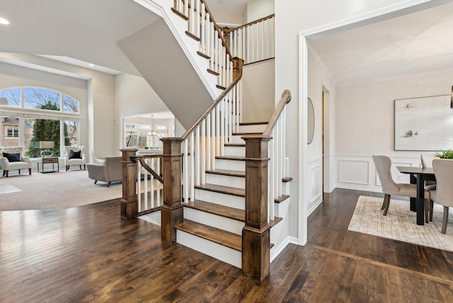 stairs with hardwood / wood-style flooring and an inviting chandelier