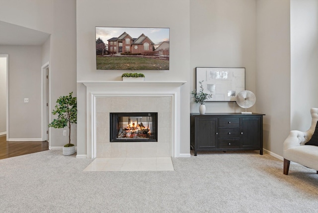 living area featuring light carpet and a tile fireplace