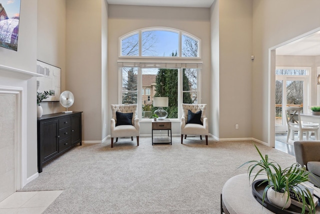 living area with light colored carpet and a high ceiling