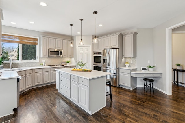 kitchen featuring a center island, dark wood-type flooring, a kitchen breakfast bar, decorative light fixtures, and stainless steel appliances