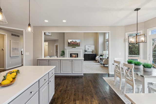 kitchen featuring white cabinetry, dark hardwood / wood-style flooring, decorative light fixtures, and an inviting chandelier