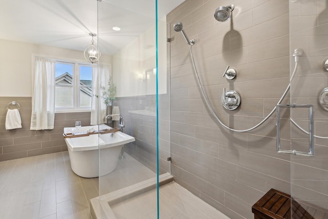 bathroom featuring tile patterned floors, separate shower and tub, and tile walls