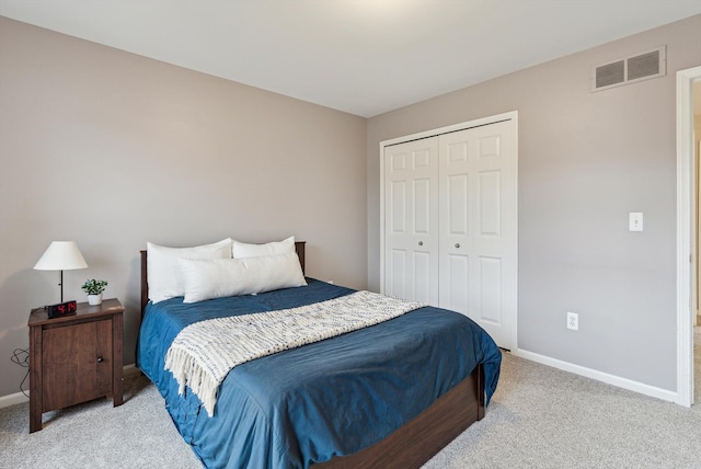 bedroom featuring light colored carpet and a closet