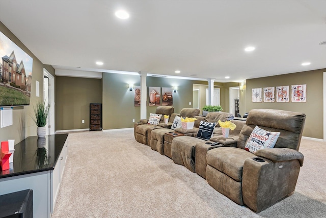 cinema room with decorative columns and light colored carpet