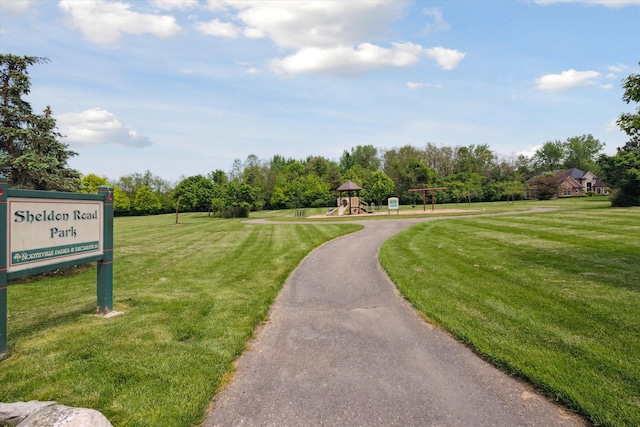 view of property's community with a playground and a yard