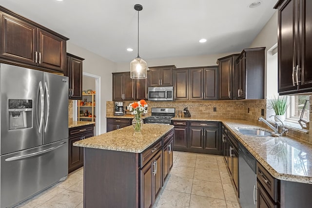 kitchen featuring pendant lighting, backsplash, sink, a kitchen island, and stainless steel appliances