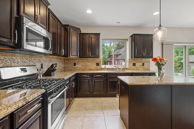 kitchen featuring pendant lighting, backsplash, stainless steel appliances, and a healthy amount of sunlight