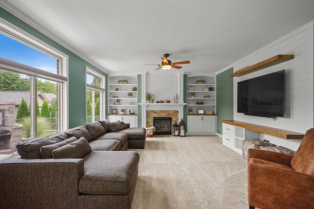 living room featuring built in shelves, crown molding, ceiling fan, and light carpet