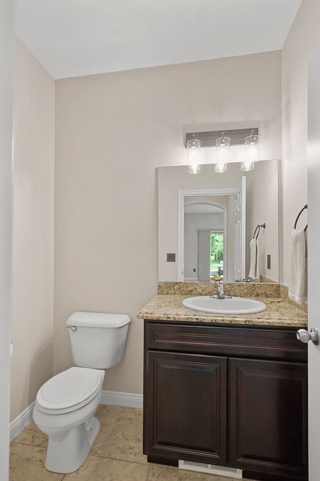 bathroom with tile patterned flooring, vanity, and toilet