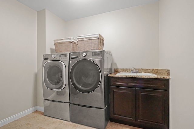 laundry area with sink, light tile patterned floors, cabinets, and independent washer and dryer