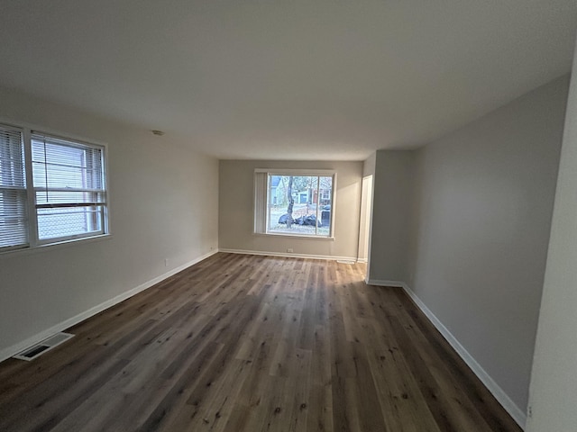 empty room with dark hardwood / wood-style flooring