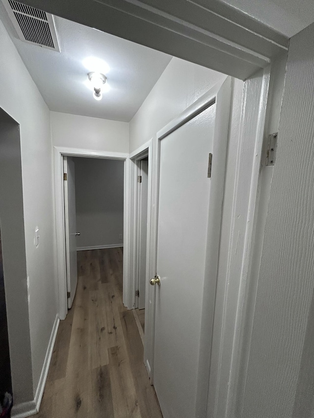 hallway with hardwood / wood-style floors