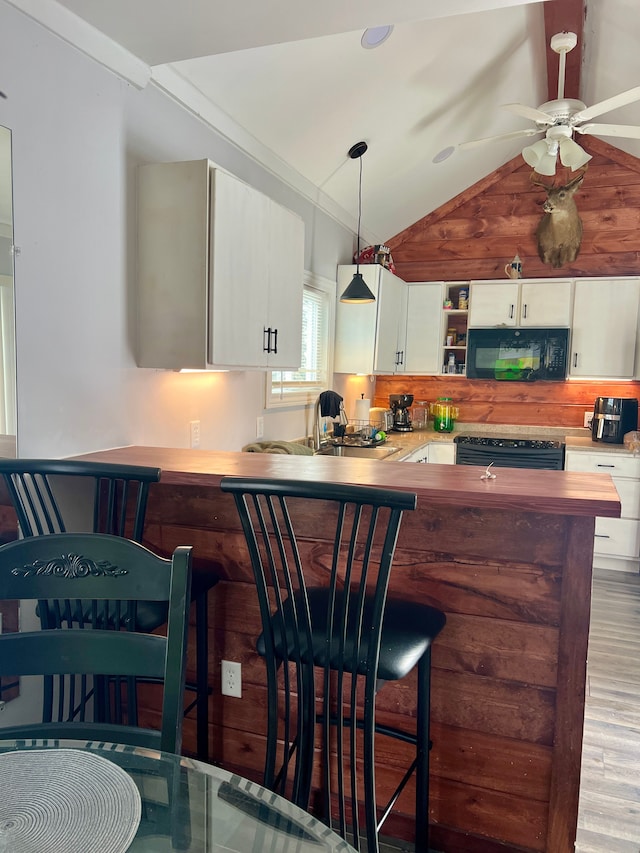 kitchen with ceiling fan, sink, decorative light fixtures, white cabinets, and black appliances