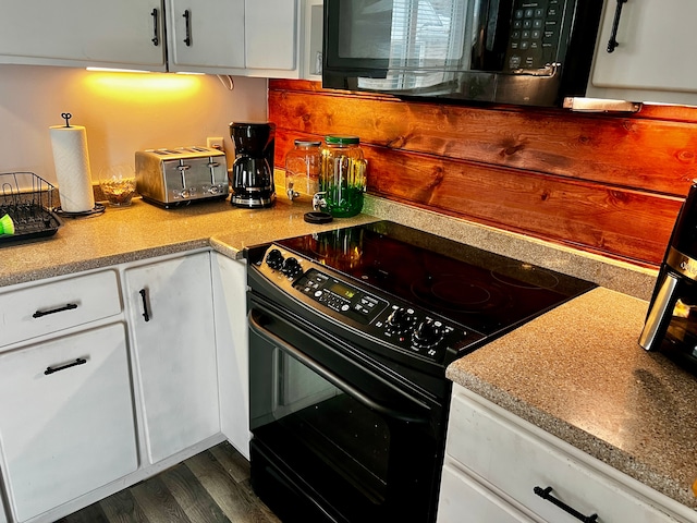 kitchen with black appliances, dark hardwood / wood-style floors, and white cabinets