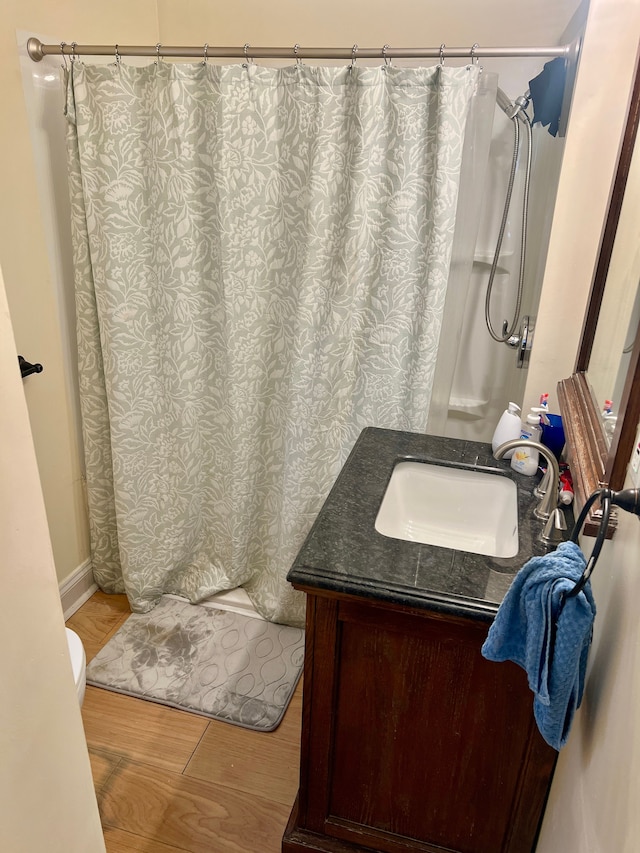 bathroom featuring shower / bath combo with shower curtain, vanity, and wood-type flooring