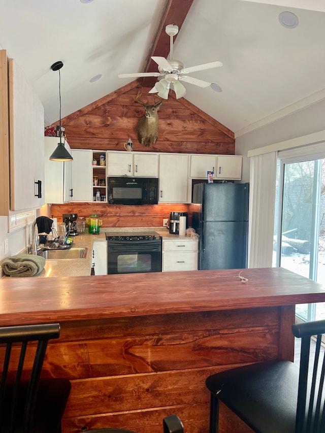 kitchen with sink, black appliances, pendant lighting, lofted ceiling with beams, and white cabinetry