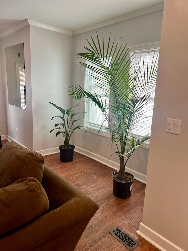 sitting room with hardwood / wood-style flooring and ornamental molding