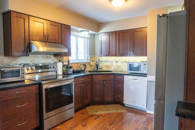 kitchen featuring dark hardwood / wood-style flooring, decorative backsplash, sink, and white appliances