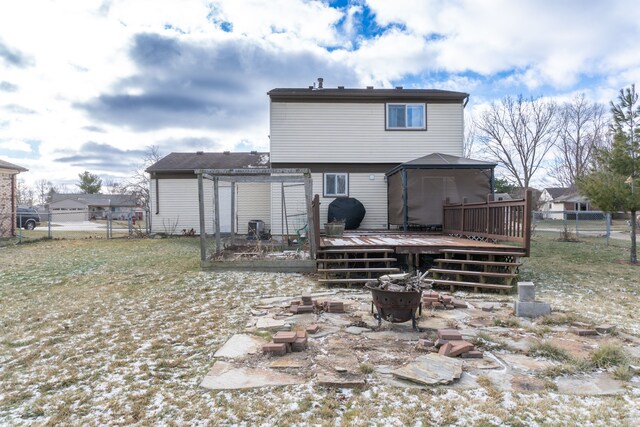 rear view of property with a gazebo, a fire pit, and a deck