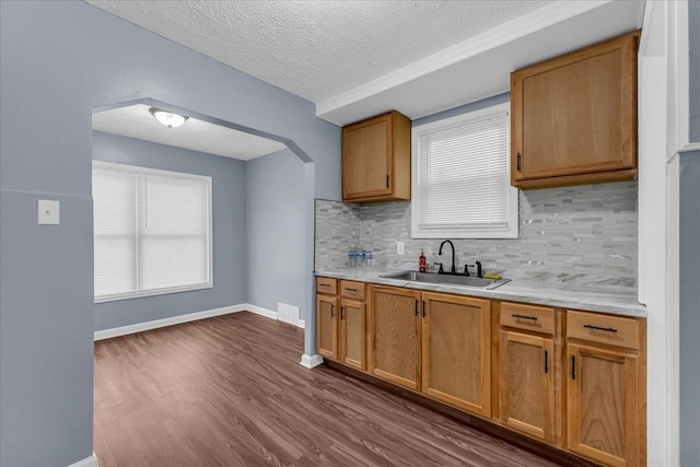 kitchen featuring decorative backsplash, sink, dark hardwood / wood-style floors, and a textured ceiling