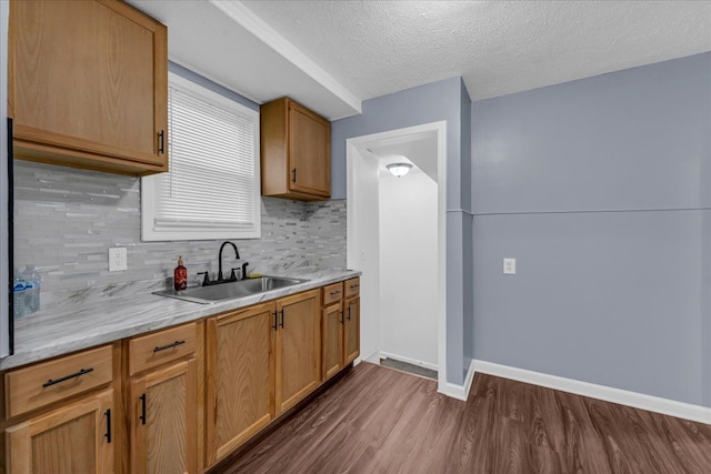 kitchen featuring a textured ceiling, tasteful backsplash, dark hardwood / wood-style floors, and sink