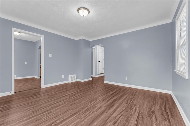 spare room with hardwood / wood-style floors and a textured ceiling