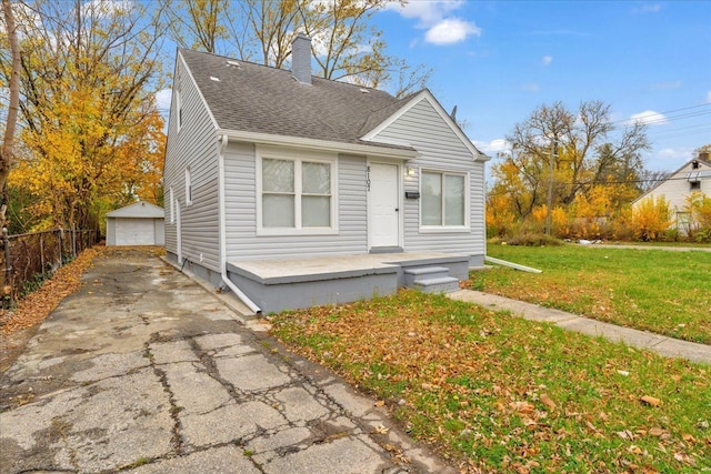 bungalow featuring an outbuilding, a front lawn, and a garage