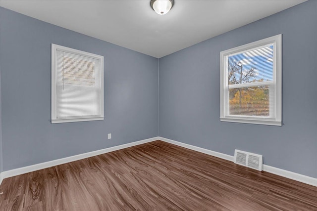 unfurnished room with hardwood / wood-style flooring