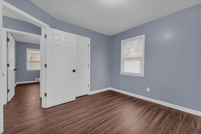 unfurnished bedroom featuring dark wood-type flooring and a closet