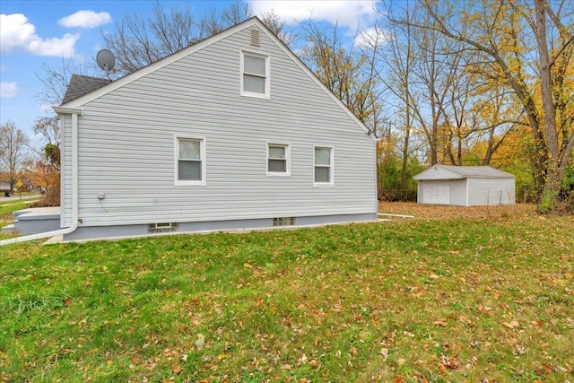 view of property exterior featuring a lawn, an outbuilding, and a garage