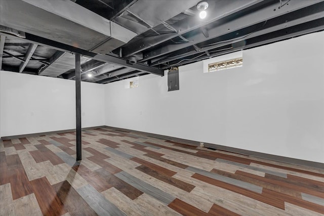 basement with electric panel and wood-type flooring