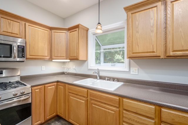 8816 Hathaway Rd, Kalamazoo, MI 49009 - kitchen with hanging light fixtures, dark countertops, a sink, and stainless steel appliances