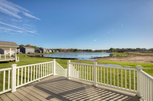 wooden terrace featuring a water view and a lawn