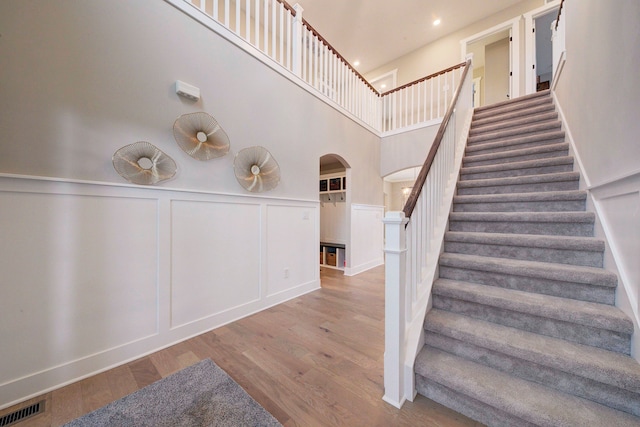 stairway featuring hardwood / wood-style floors and a high ceiling