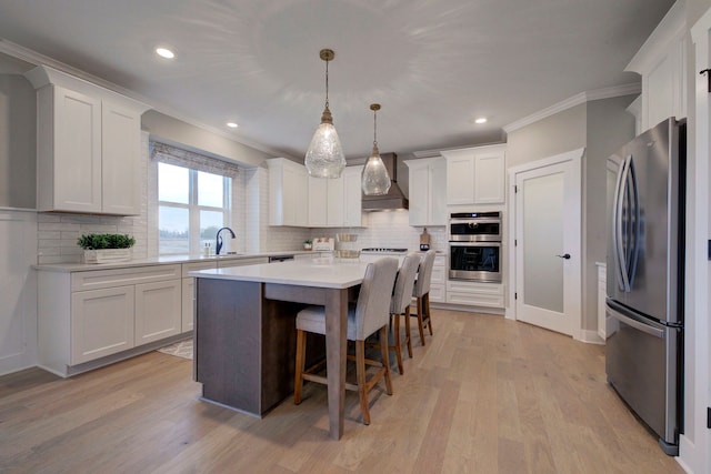 kitchen featuring a center island, hanging light fixtures, stainless steel appliances, premium range hood, and white cabinets