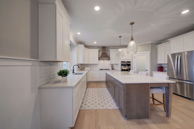 kitchen featuring white cabinetry, a center island, sink, custom range hood, and appliances with stainless steel finishes