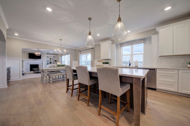 kitchen with white cabinets, pendant lighting, a center island, and stainless steel dishwasher