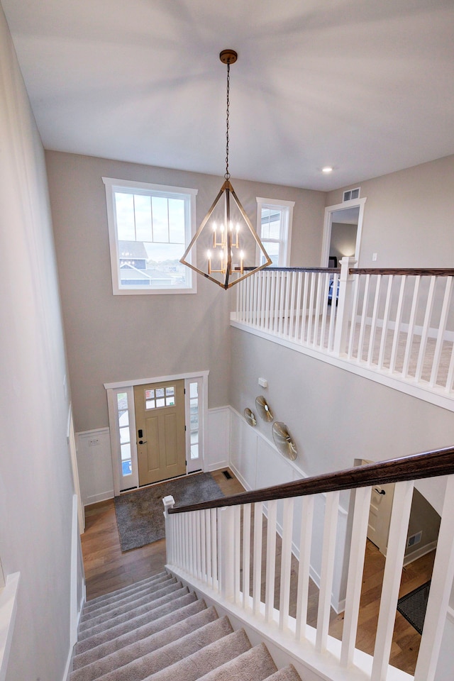 entryway with hardwood / wood-style floors, a notable chandelier, and a high ceiling