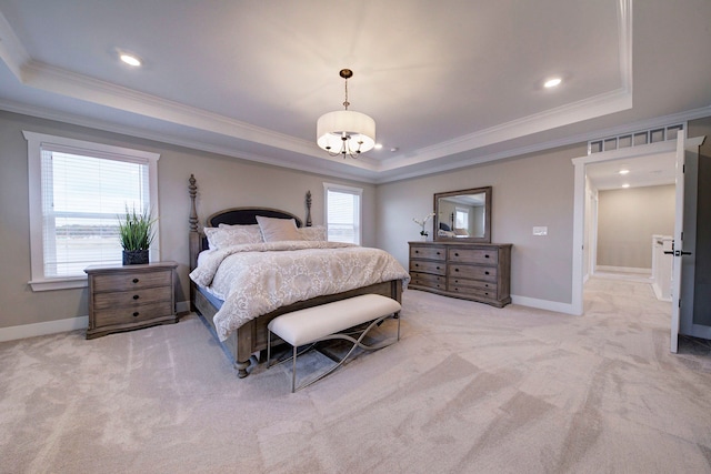 carpeted bedroom with a tray ceiling and ornamental molding