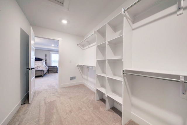 walk in closet featuring light carpet