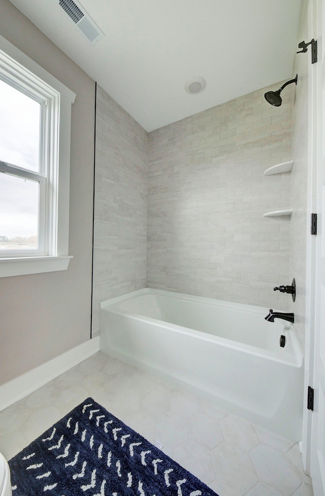 bathroom with tile patterned flooring and tiled shower / bath