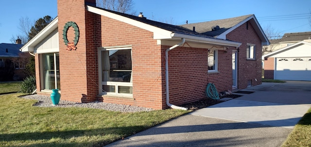 view of side of property featuring a garage, a lawn, and an outdoor structure